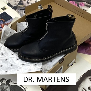 Dr.martens-Boot-in-der-Farbe-schwarz-liegt-in-einem-Dr.martens-Schuhkarton-aund-das-auf-Schallplatten-und-ein-Button-Dr.marrtens Dr.martens-Boot-in-der-Farbe-schwarz-liegt-in-einem-Dr.martens-Schuhkarton-aund-das-auf-Schallplatten-und-ein-Button-Dr.marrtens