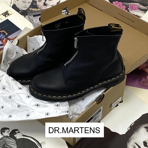Dr.martens Boot in der Farbe schwarz liegt in einem Dr.martens Schuhkarton aund das auf Schallplatten und ein Button Dr.marrtens Dr.martens Boot in der Farbe schwarz liegt in einem Dr.martens Schuhkarton aund das auf Schallplatten und ein Button Dr.marrtens