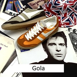 Gola-mit-Sneaker-orange-und-beige-braun-und-weissen-Striefen-und-gumsohle-auf-eine-Vielzahl-von-Schallplatten-und-einem-Schlapphu-mit-englischer-Flagge-und-Button-Gola Gola-mit-Sneaker-orange-und-beige-braun-und-weissen-Striefen-und-gumsohle-auf-eine-Vielzahl-von-Schallplatten-und-einem-Schlapphu-mit-englischer-Flagge-und-Button-Gola
