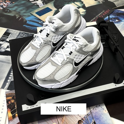 Nike Herrensneaker weiß mit silber und schwarz und heller Sohle auf einem Thorens Plattensspieler und verschiedenen Schallplatten und Button Nike Nike Herrensneaker weiß mit silber und schwarz und heller Sohle auf einem Thorens Plattensspieler und verschiedenen Schallplatten und Button Nike