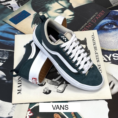 Vans Herren Sneaker grün mit weißen Streifen und weißer Sohle auf einem Berg von Schallplatten mit button Vans Vans Herren Sneaker grün mit weißen Streifen und weißer Sohle auf einem Berg von Schallplatten mit button Vans